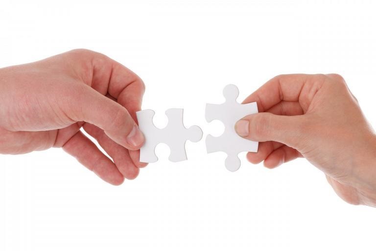 Dłonie łączące puzzle